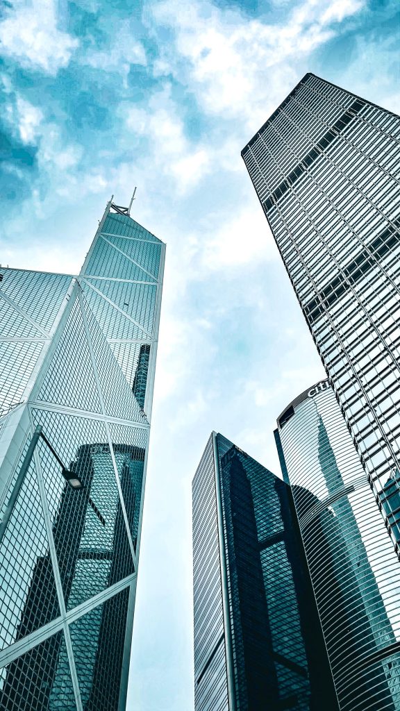 Uplifting view of modern skyscrapers on Hong Kong Island against a blue sky.